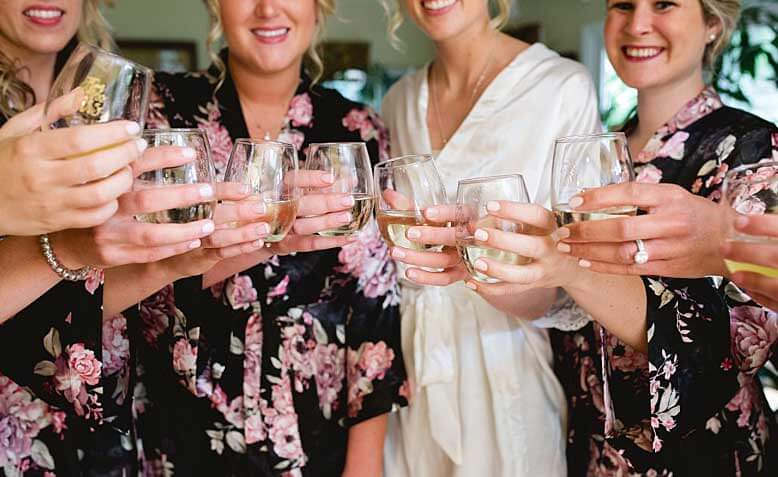 Bridesmaids get ready for wedding and enjoy a glass of wine