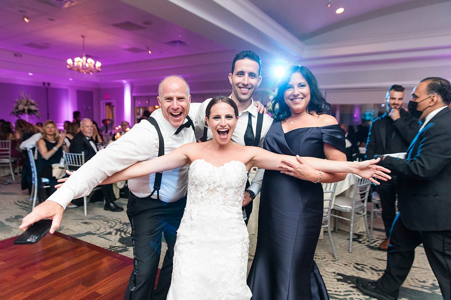 A group of people posing for a photo at a new jersey wedding reception.