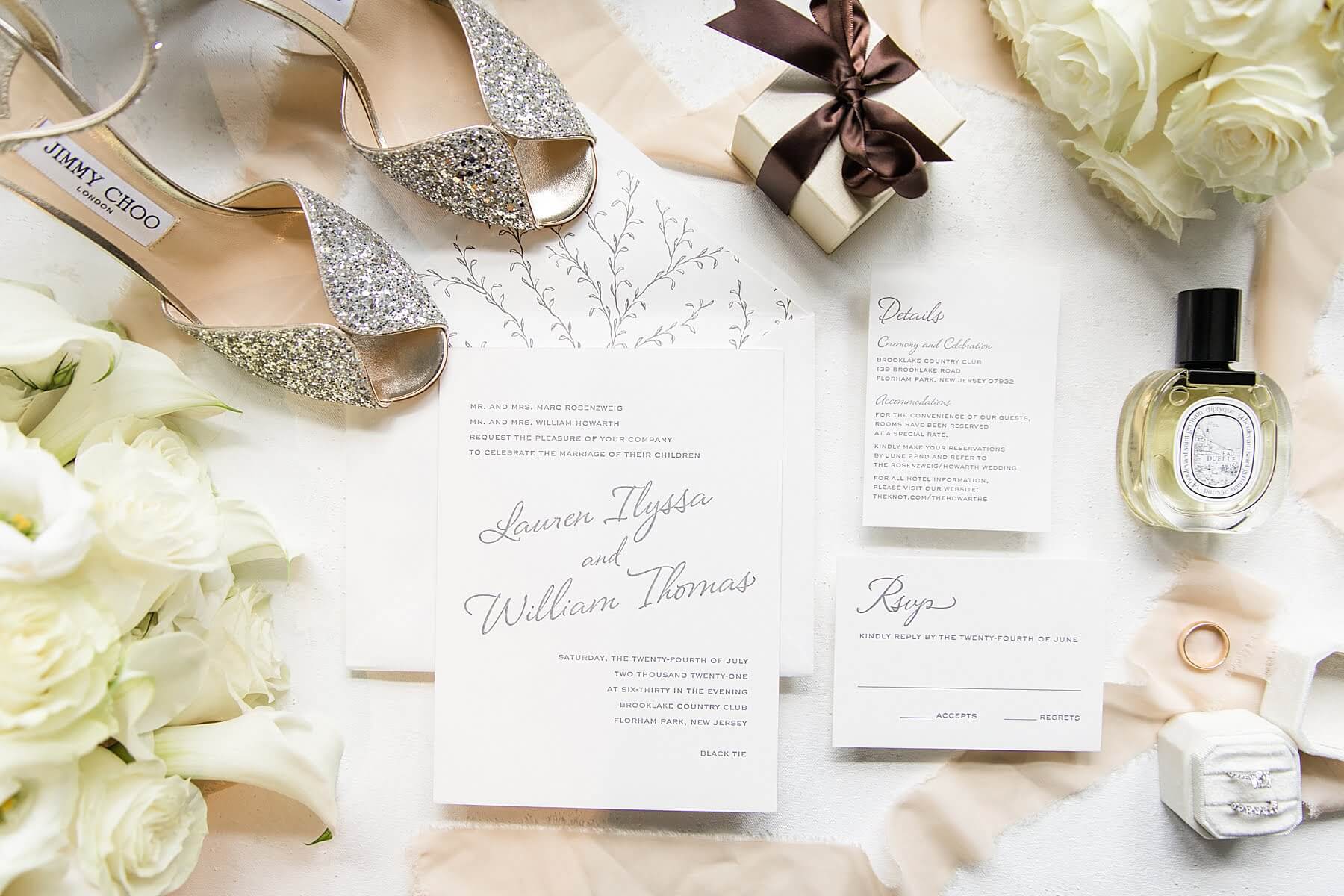 A variety of wedding items, including a wedding invitation and wedding shoes, are artfully arranged on a table at one of the exquisite Florham Park wedding venues in New Jersey.