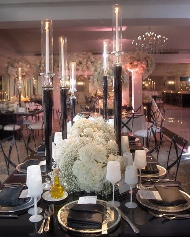 Elegant kosher wedding table setting in NJ featuring tall candlesticks and a lush white floral centerpiece.
