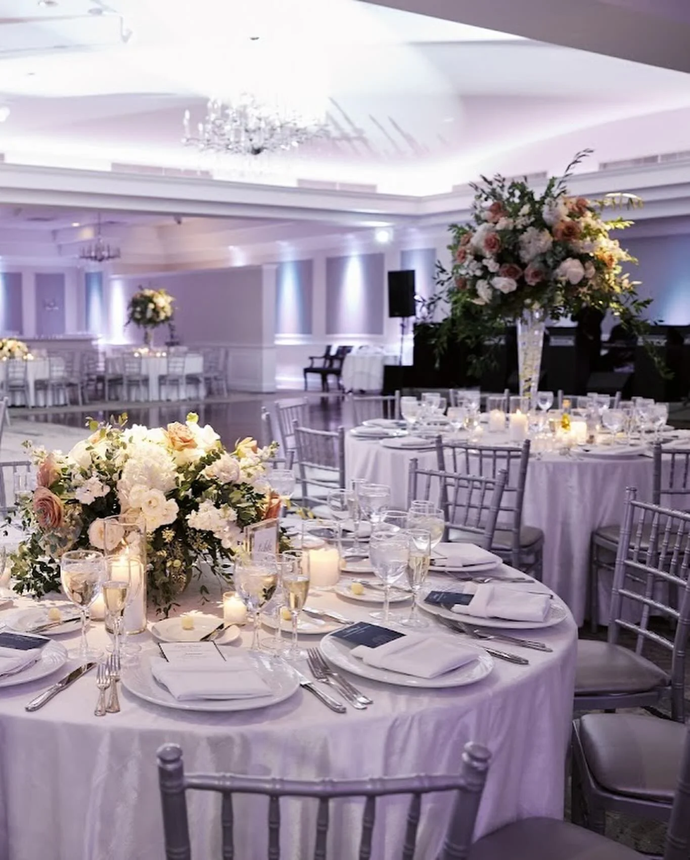 Elegant banquet hall setup for kosher weddings in NJ with floral centerpieces and silver chiavari chairs.