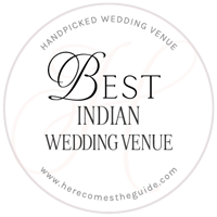 Circular badge with the text "Best Indian Wedding Venue," "Handpicked Wedding Venue," and "www.herecomestheguide.com.