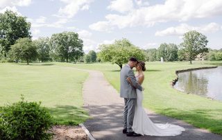 Bride and groom embracing beside the lake at their Brooklake wedding